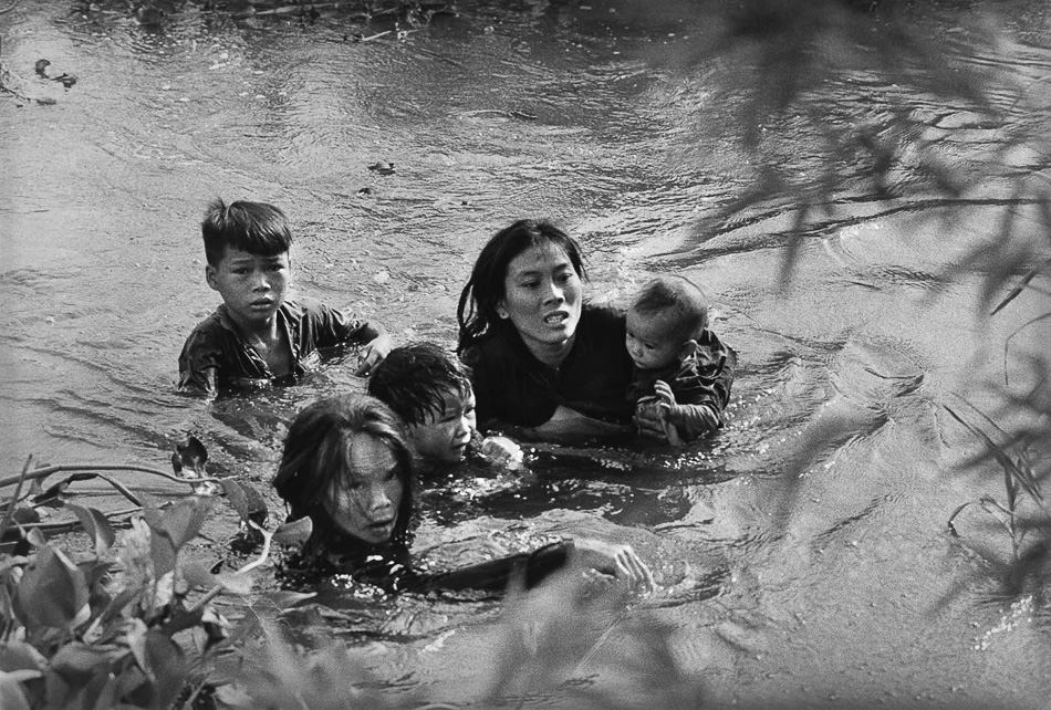 Kyōichi Sawada (Japan), A mother and her children wade across a river in Vietnam to escape US bombing, 1965.